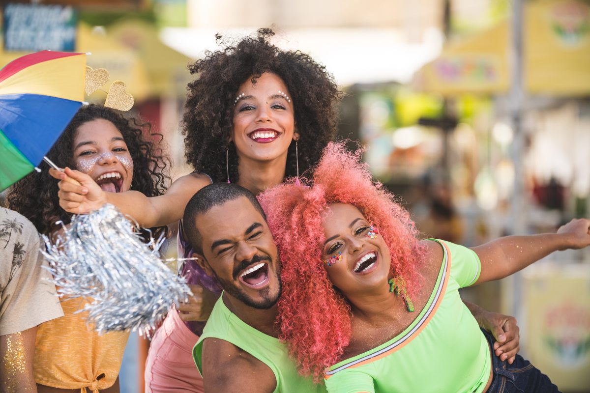 Friends having fun on the street during a carnival © iStock