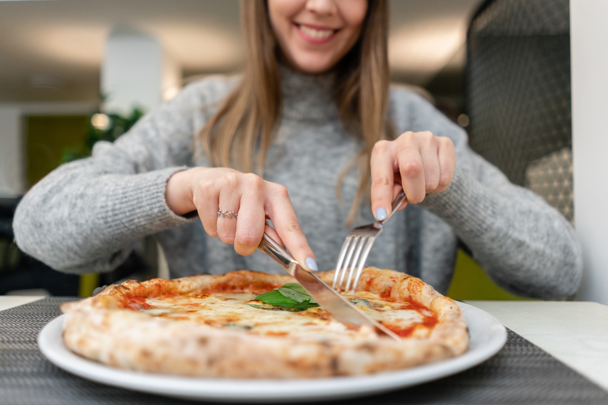 Woman eating Neapolitan pizza © shutterstock